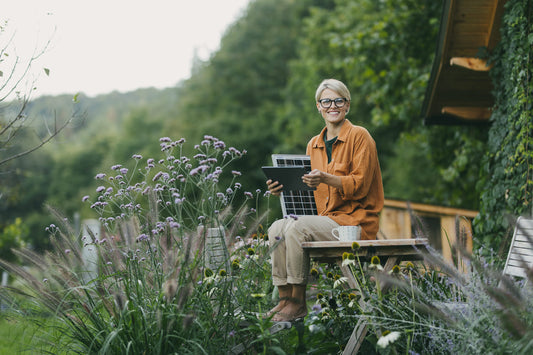 A woman sitting in her off-grid garden.